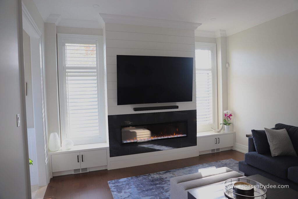 modern living family room with blue sectional and bold black and white fireplace, wall art and decor.