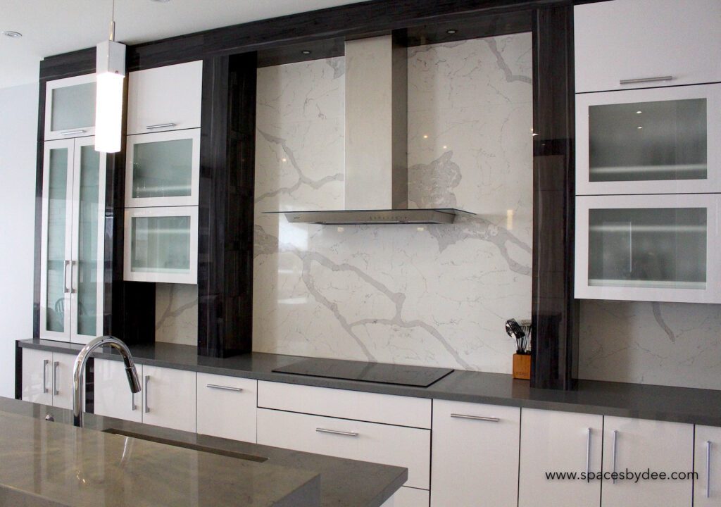 super modern large white, black and grey minimalistic kitchen with stone backsplash.