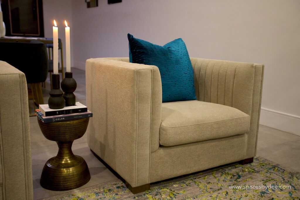 interior designer styles chair with candles and books.