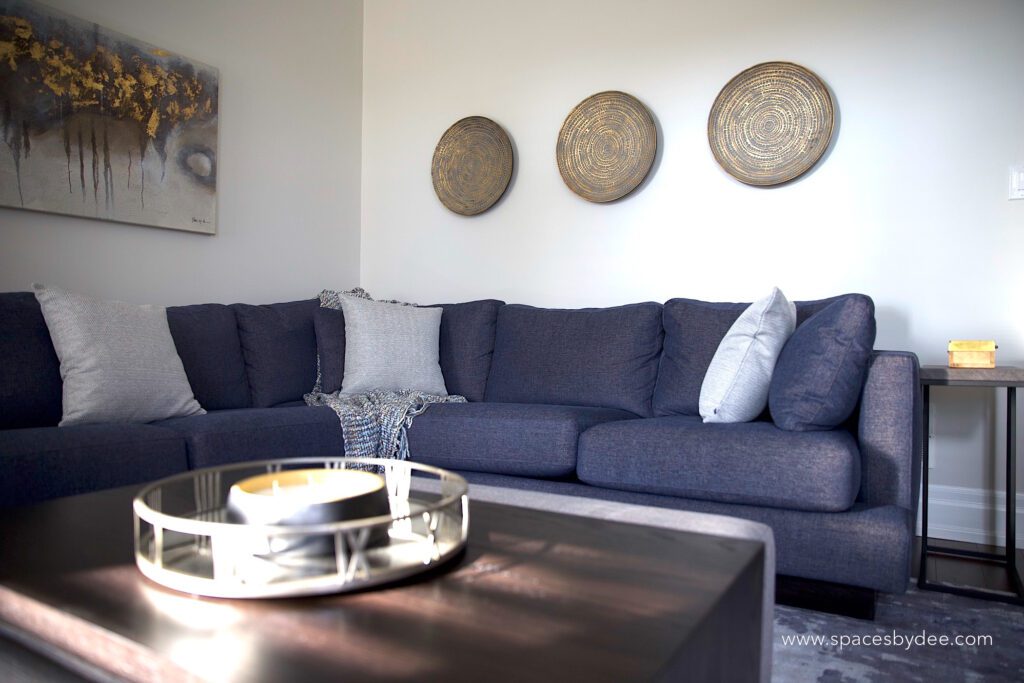 modern living family room with blue sectional and bold black and white fireplace, wall art and decor.