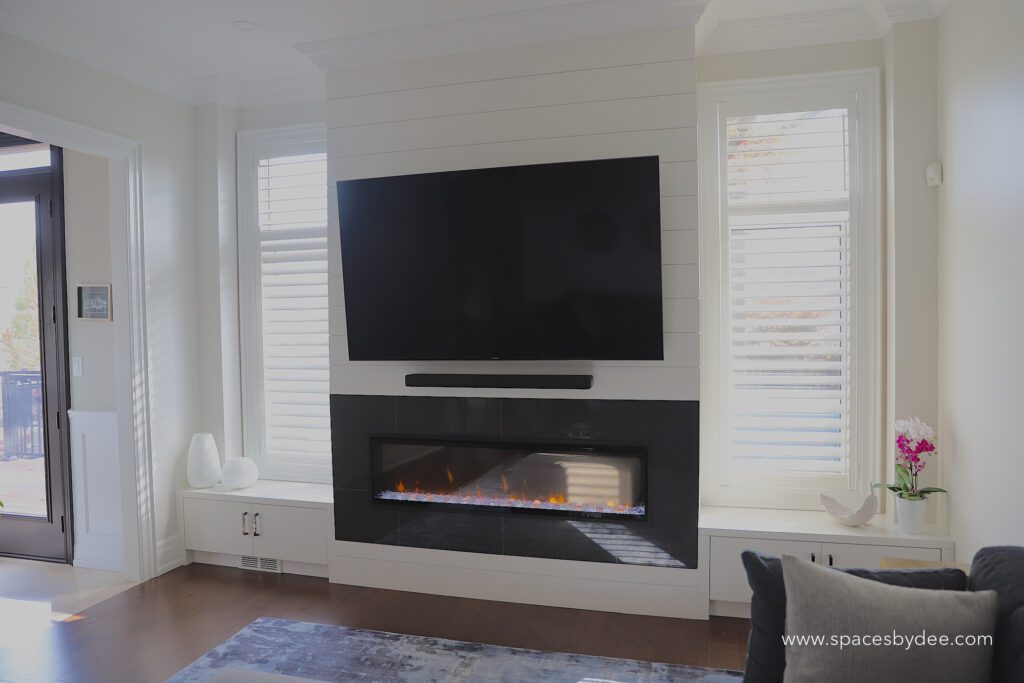 modern living family room with blue sectional and bold black and white fireplace, wall art and decor.