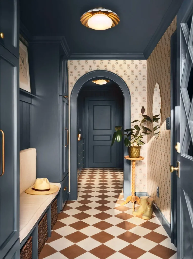 Narrow entryway painted deep navy with patterned wallpaper, an arched doorway and a checkerboard tile floor