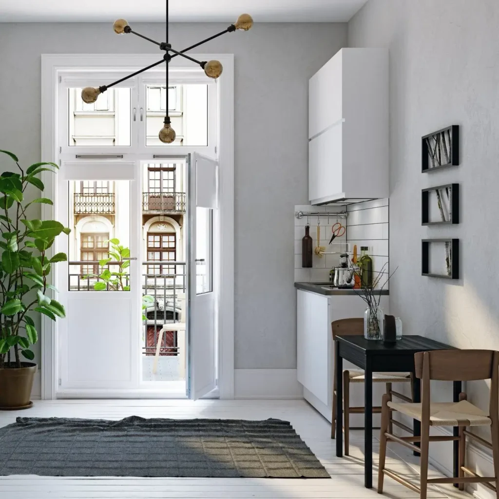 Small open kitchen and dining nook with furniture floated away from the walls and a modern pendant light